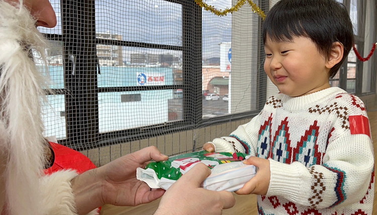写真：サンタクロースからプレゼントを受け取る子ども